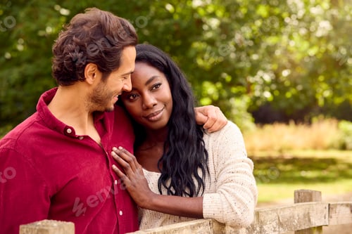 Preview: Loving Mixed Race Couple Leaning On Fence On Walk In Countryside