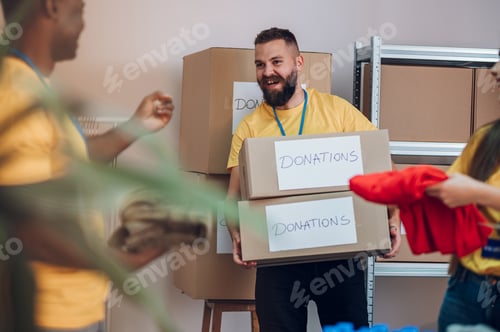 Preview: Group of multiracial volunteers working in community charity donation center