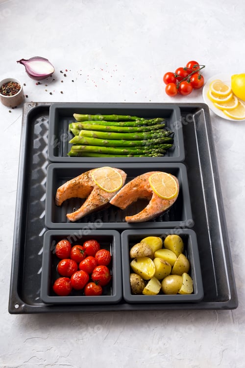 Preview: Baked healthy food on a baking sheet asparagus, red fish, potatoes and cherry tomatoes