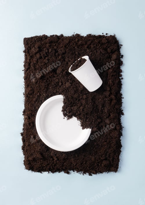 Preview: Paper plate and glass on soil on blue background flat lay composition, top view