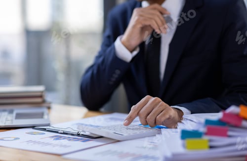 Preview: Man Working on Financials at Office Desk