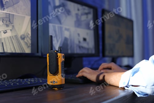Preview: Female security guard with portable transmitter monitoring modern CCTV cameras indoors, closeup