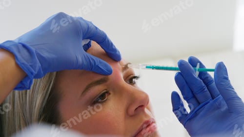 Preview: Woman Sitting In Chair Being Give Botox Injection Between Eyes By Female Doctor