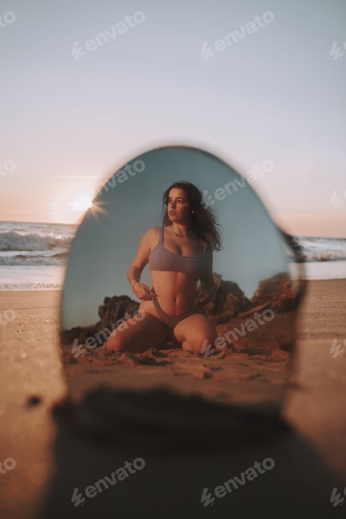 Preview: Vertical shot of a sexy Spanish Caucasian woman posing in a bikini on a sandy beach