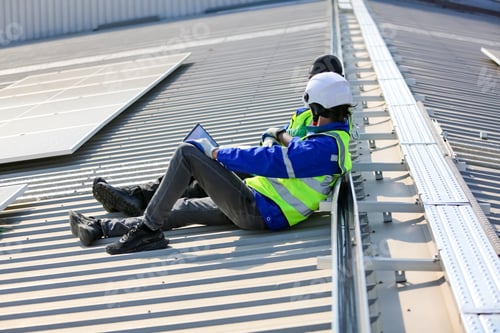 Preview: Solar panel installer installing solar panels on roof of warehouse