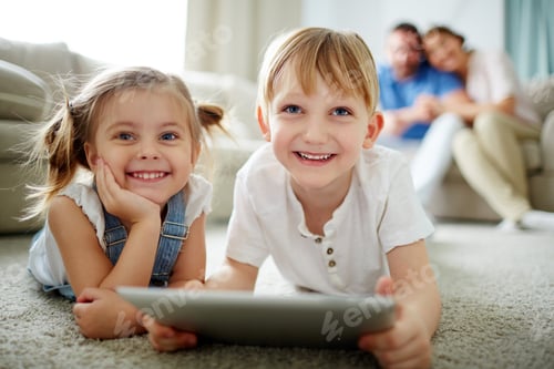Preview: Smiling Children Playing Tablet Device at Home