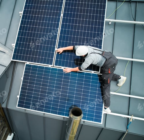 Preview: Man technician mounting photovoltaic solar panels on roof of house with help of hex key.