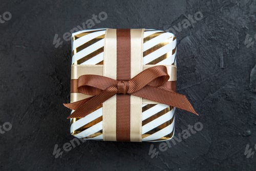 Preview: top view valentines day present in square shaped with brown bow on dark background love couple gift