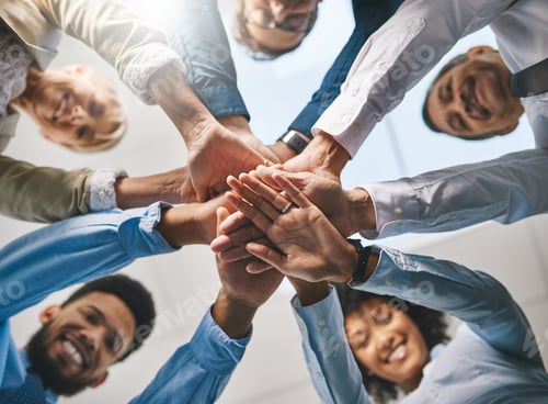 Preview: Portrait of a group of businesspeople joining their hands together in unity in an office