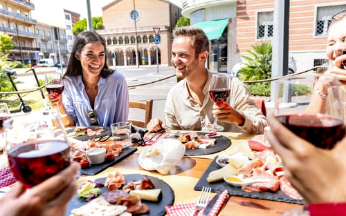 Preview: Milenial friends having fun drinking and toasting red wine at lunch party on sunny day