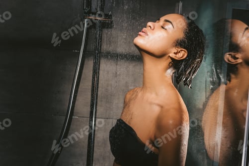 Visualização: atraente garota afro-americana com os olhos fechados tomando banho
