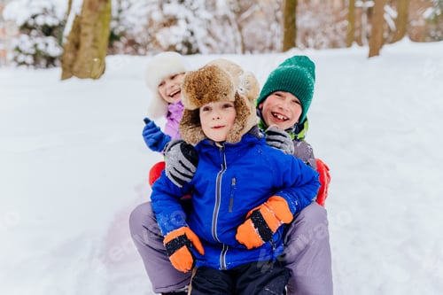 Preview: Group portrait of three children in winter playing in snowy park,