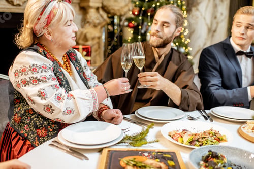 Preview: Elegantly dressed people having a festive dinner indoors