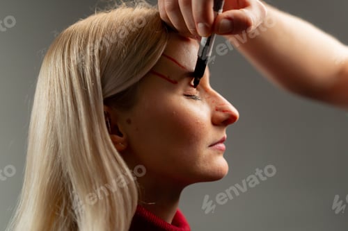 Preview: in a plastic surgery clinic doctor makes markings on the face of a young girl before surgery