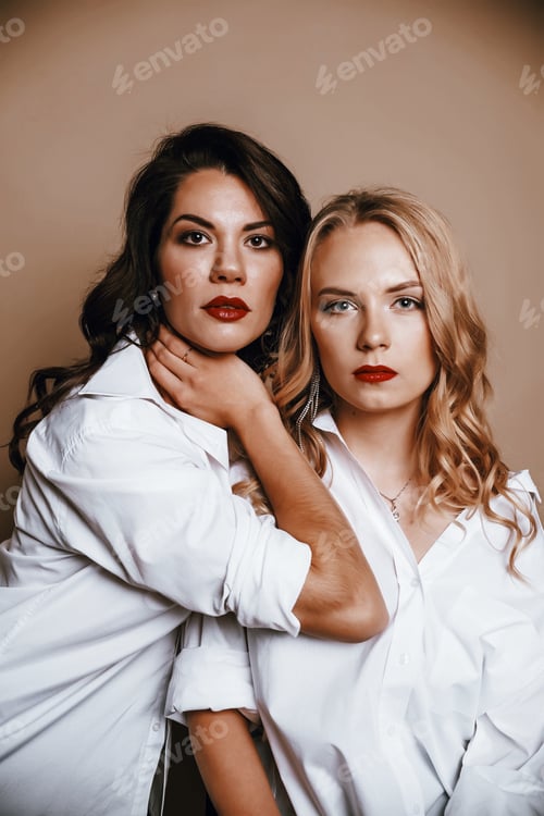 Preview: Two Women in White Shirts Pose in Studio