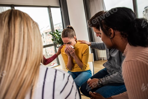 Preview: Diverse group of people sitting in circle in group therapy session.