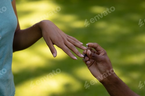 Preview: Young man putting wedding ring woman finger