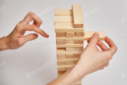 Preview: Family play board game. Hands take wooden block from tower