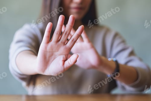 Preview: Closeup image of a woman outstretched hand and showing stop hand sign
