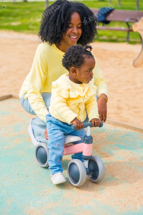 Preview: African girl learning to ride a bike with her mother
