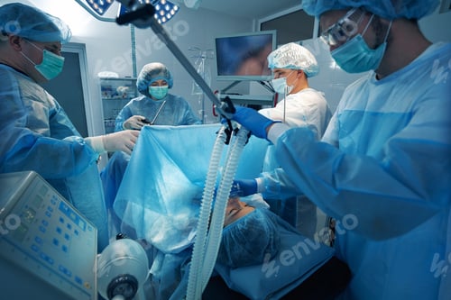 Preview: Anesthetist holding oxygen mask pressed to patient face during operation