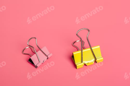Preview: Colorful paper clips on a vibrant pink background create a playful office scene