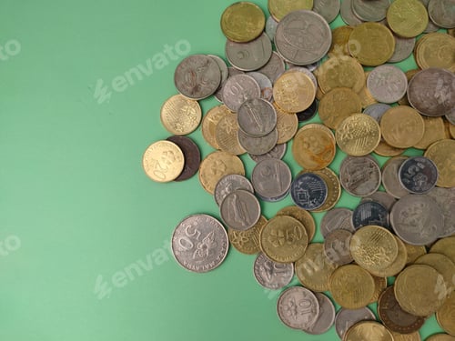 Preview: Top view coins scattered on a green background.