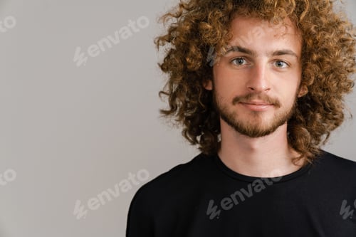 Preview: Young curly man with ginger hair posing and looking at camera
