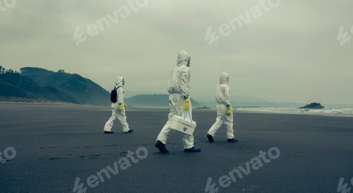 Preview: People with bacteriological protection suits walking on the beach