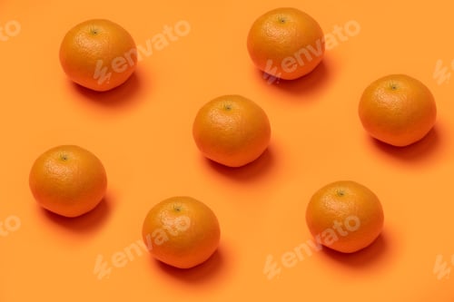Preview: Closeup of fresh tangerines on an orange surface