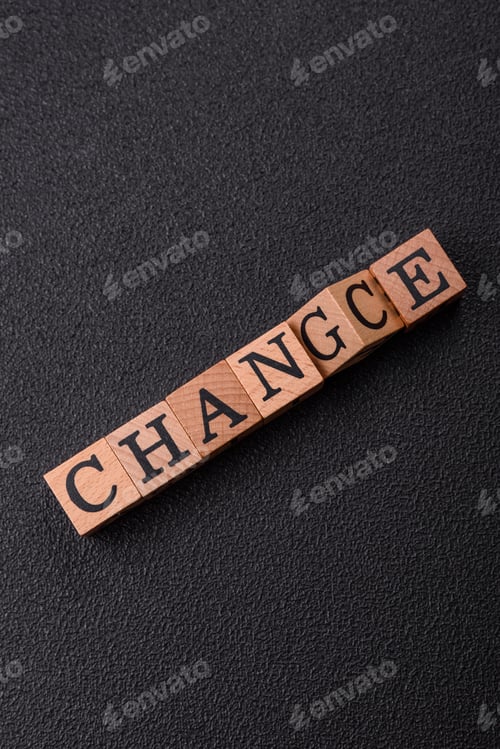 Preview: The inscription chance or change with wooden cubes on a dark concrete background
