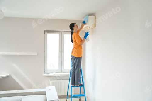 Preview: Cleaning company worker dusting the air conditioner