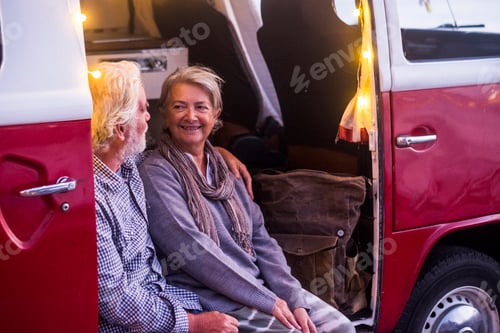 Preview: Senior couple traveling in a vintage van, watching sunset at the sea