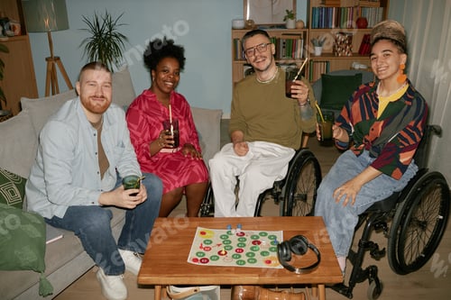 Preview: Diverse Young Adults in Wheelchairs Smiling and Toasting Drinks at Birthday