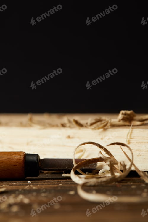 Preview: closeup shot of wooden pieces and chisel on brown table