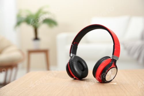 Preview: Stylish headphones on table indoors. Space for text