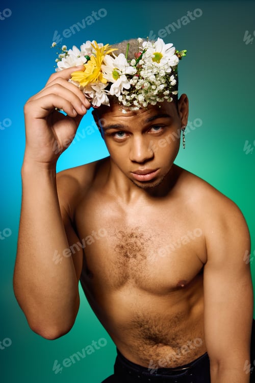 Preview: Young man showcasing fashion and beauty with floral accessories in studio lighting