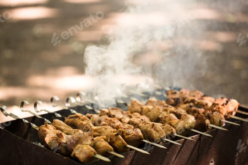 Preview: Marinated shashlik preparing on a barbecue grill over charcoal. Shashlik or Shish kebab popular in