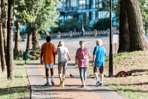 Preview: back view of senior women running with multicultural retired men in park