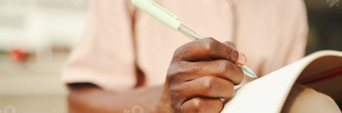 Preview: Close-up of young african student's hand taking notes, Panorama