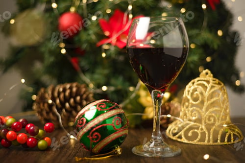 Preview: Glass of red wine on wooden table with Christmas decorations.