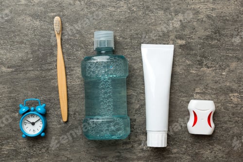 Preview: Mouthwash and other oral hygiene products on colored table top view with copy space