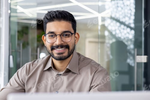 Preview: Confident businessman smiling while working in modern office environment