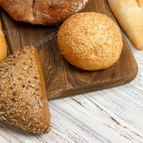 Preview: Assortment of baked bread on wooden table background. top view with copy space