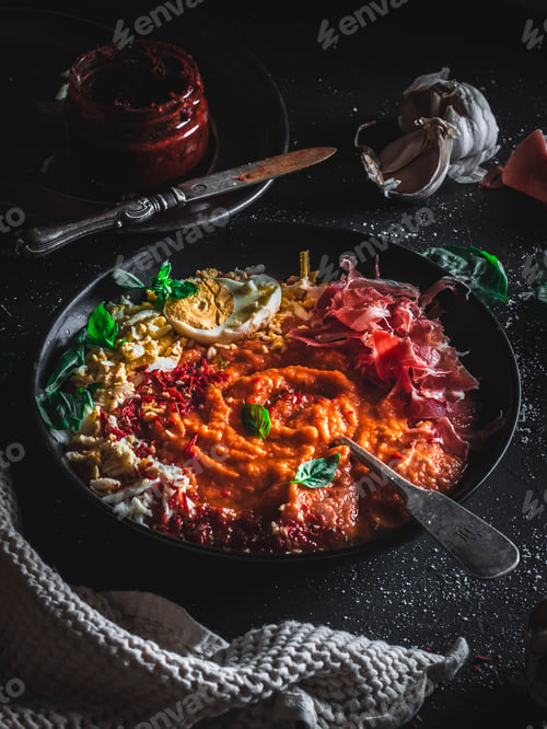 Preview: Spanish salmorejo soup with mountain bacon, basil, garlic and egg on a dark background