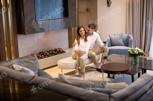 Preview: couple having a romantic evening with a glass of red wine at home