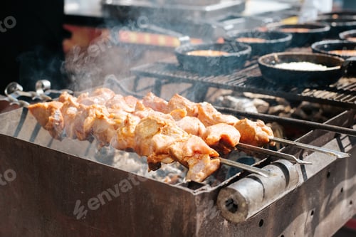 Preview: Close-up charcoal grilled meat on skewers outdoors. Smoke and aroma rising from barbecue