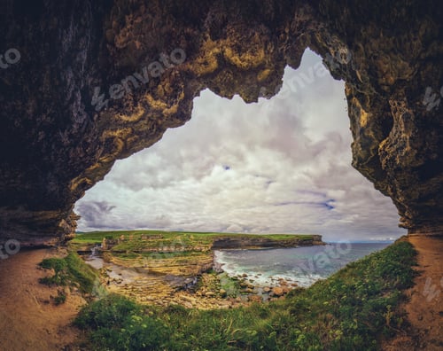 Preview: Beautiful shot of a geological formation near a lake surrounded by a forest under the cloudy skies