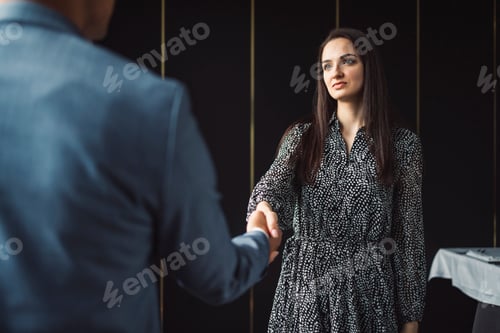 Preview: Two business people in business clothes are sitting in an office looking at a contract. One person i