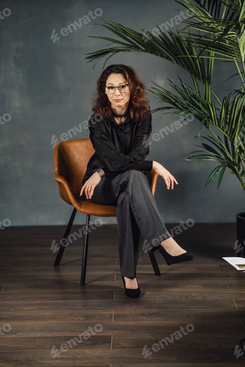 Preview: Middle-aged woman posing in the studio sitting on a chair
